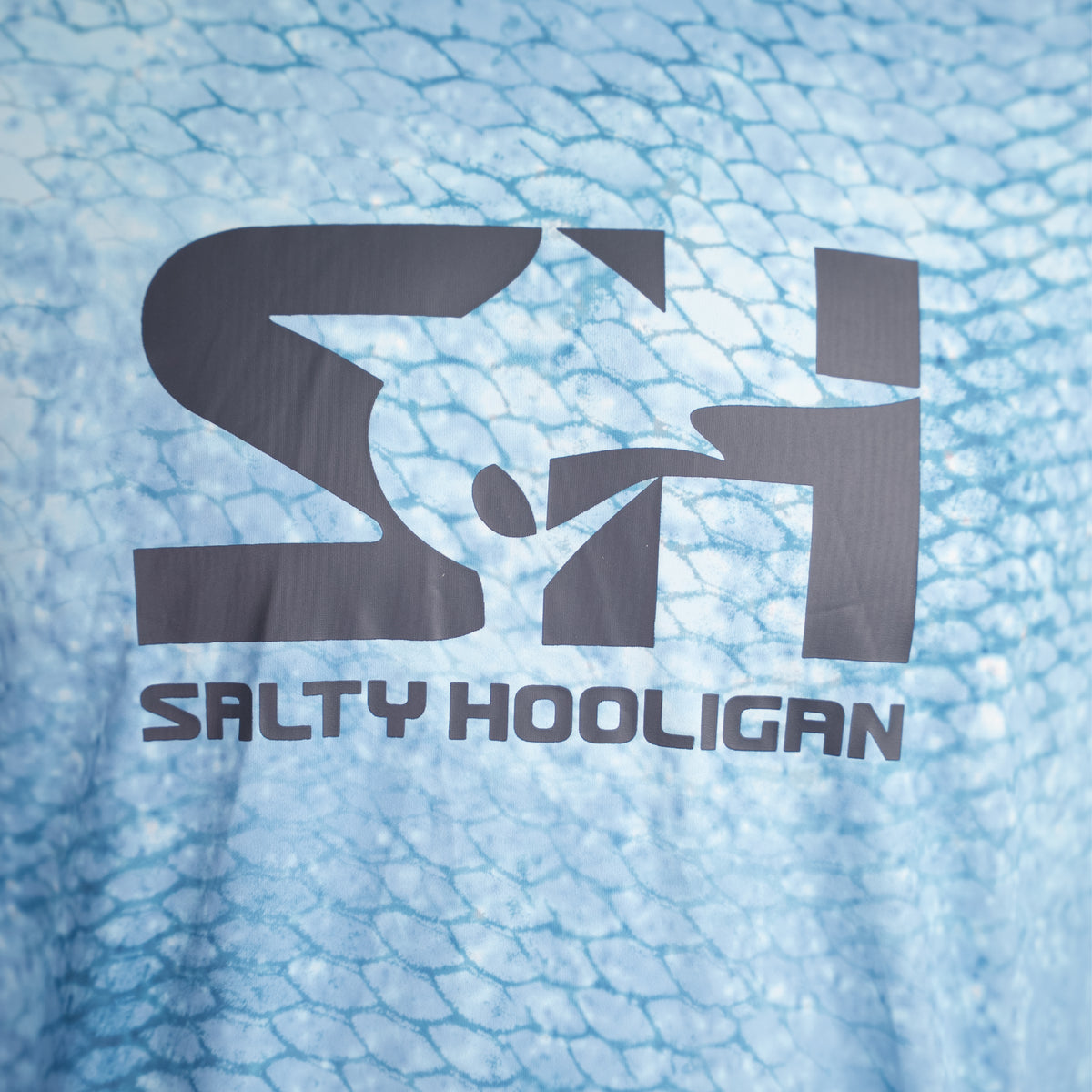 Close-up of the large Salty Hooligan logo printed on the fish scale hoodie