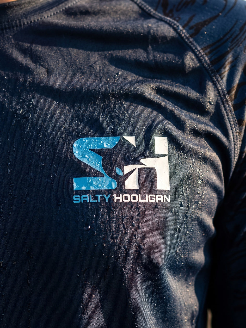Close-up of the Salty Hooligan chest logo on the navy Offshore Pursuit Crew Long Sleeve
