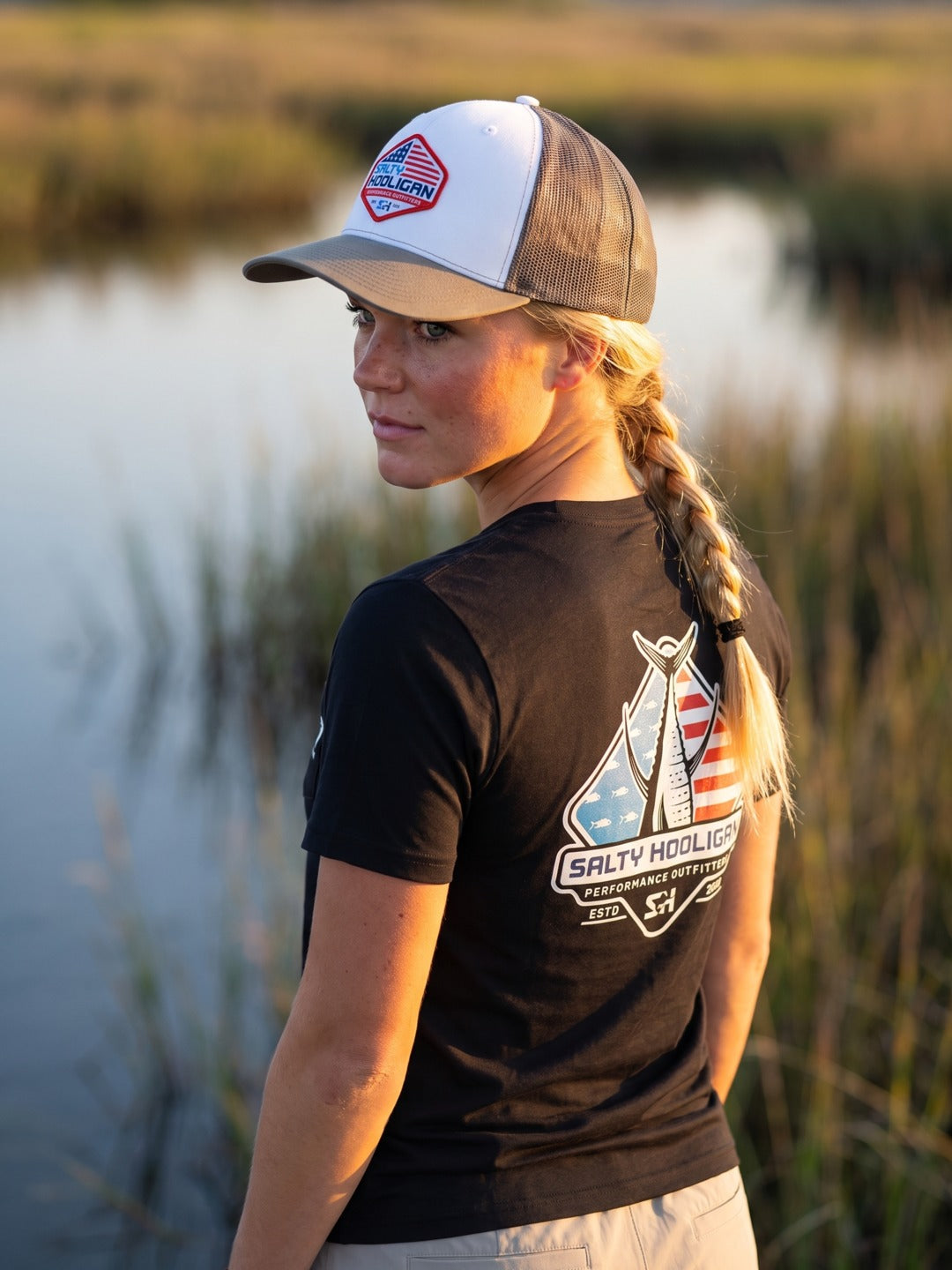 Woman in the marsh wearing the Flag Trucker, shield patch on the front