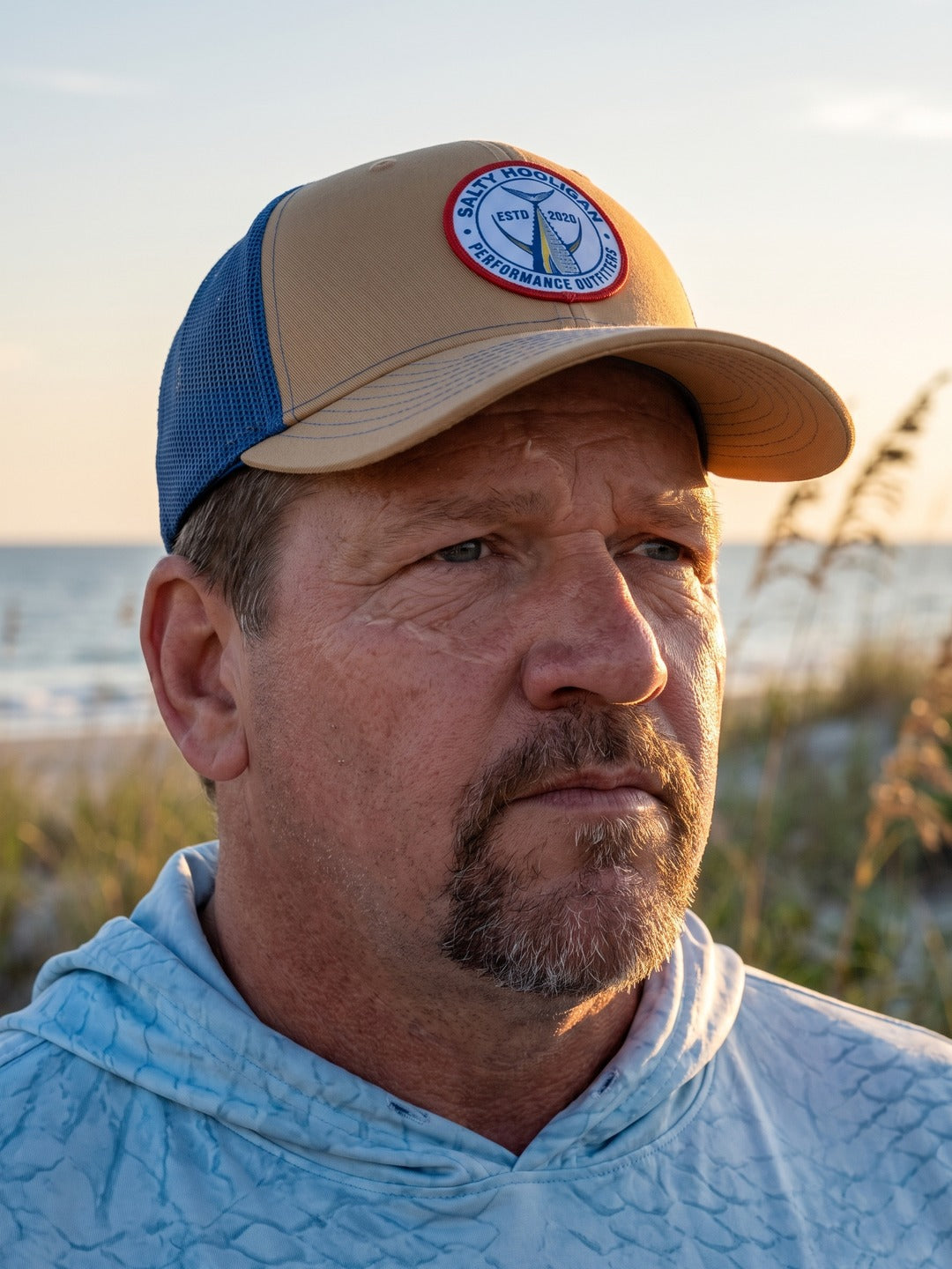 Captain wearing the Tuna Tail Patch khaki trucker on the water